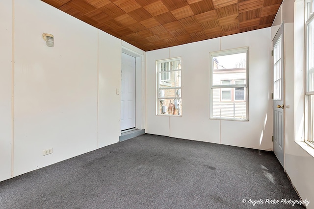 spare room with wood ceiling and dark carpet