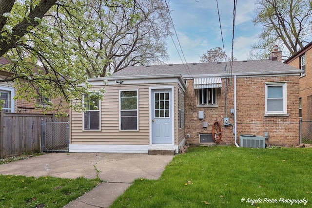 back of house featuring a patio, central AC unit, fence, and a yard
