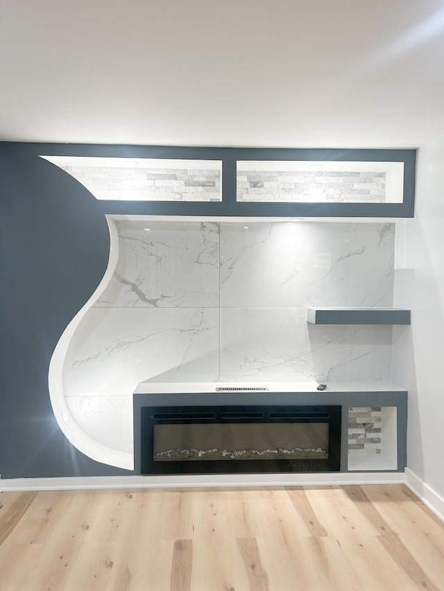 details with wood finished floors and a glass covered fireplace