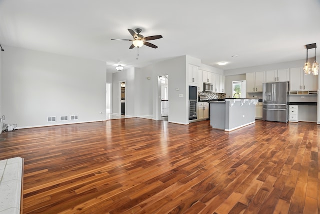 122 Periwinkle Ln, Bolingbrook, IL 60490 - unfurnished living room featuring ceiling fan, dark wood finished floors, and baseboards