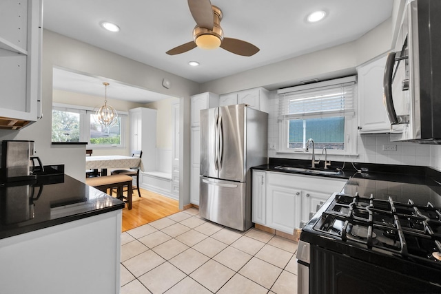kitchen featuring dark countertops, a sink, range with gas cooktop, and freestanding refrigerator