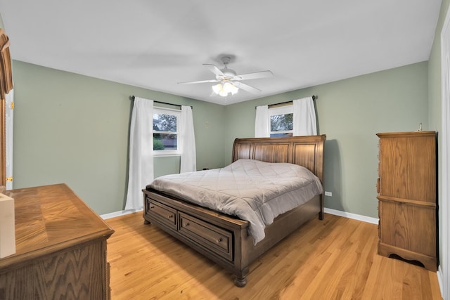 bedroom featuring light wood finished floors, multiple windows, and baseboards