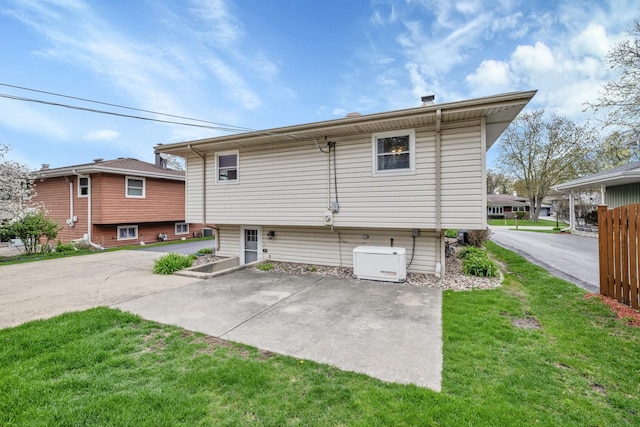 rear view of house featuring a lawn and a patio area