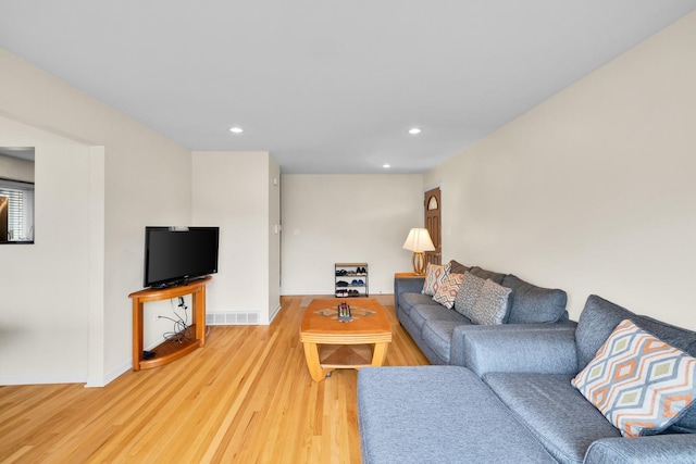 living room featuring baseboards, visible vents, light wood finished floors, and recessed lighting