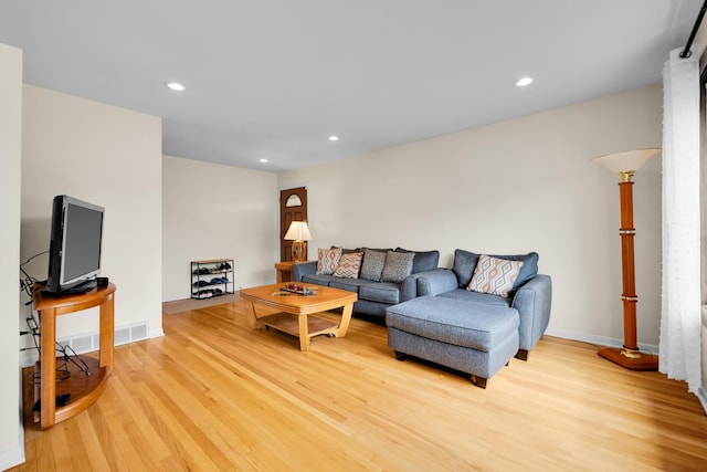 living room featuring recessed lighting, baseboards, and light wood-style floors
