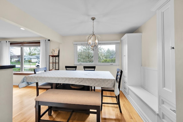 dining room with an inviting chandelier, a healthy amount of sunlight, and light wood-type flooring