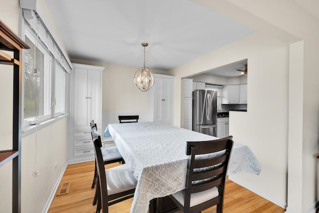 dining room featuring a notable chandelier, visible vents, baseboards, and light wood-style floors