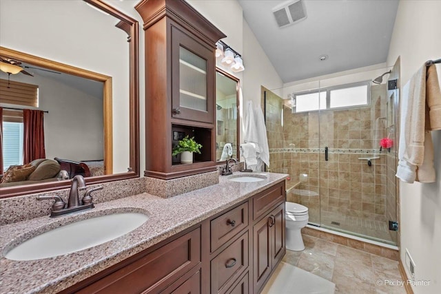 bathroom with toilet, double vanity, and a shower stall