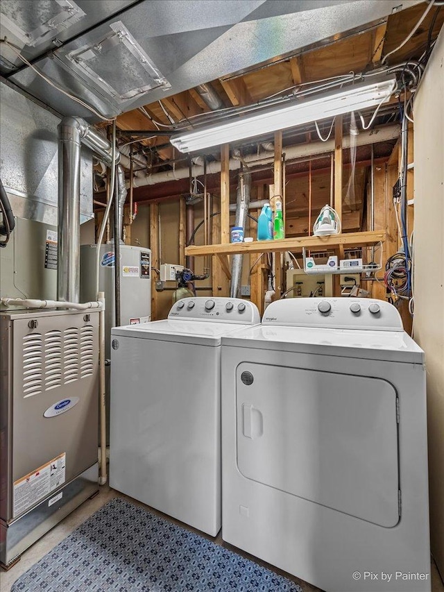 washroom featuring washing machine and dryer and heating unit