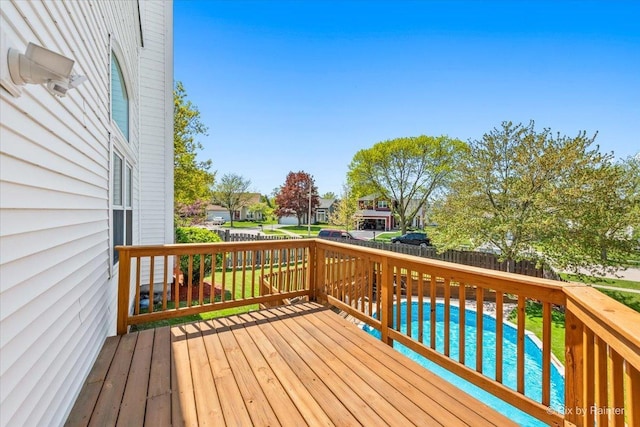wooden terrace with a fenced backyard, a residential view, and an outdoor pool