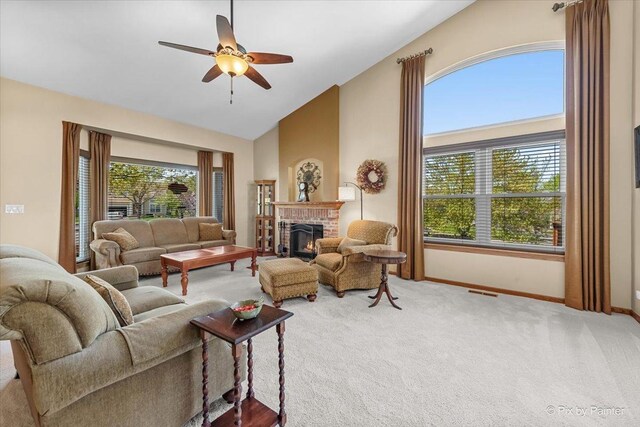 living area featuring carpet flooring, a brick fireplace, baseboards, ceiling fan, and vaulted ceiling