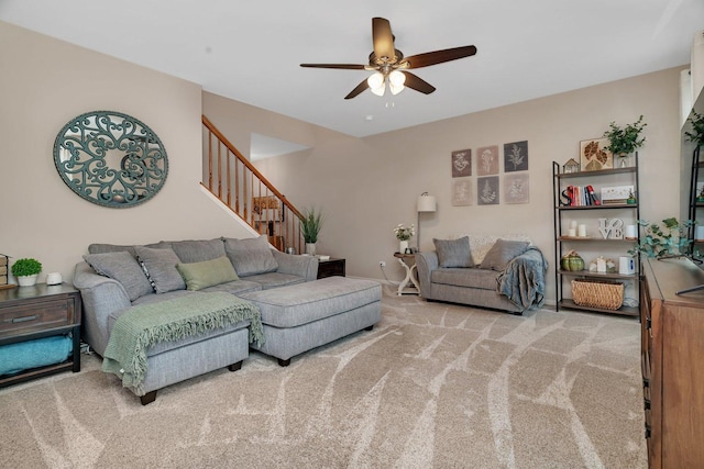 carpeted living room with stairs and ceiling fan