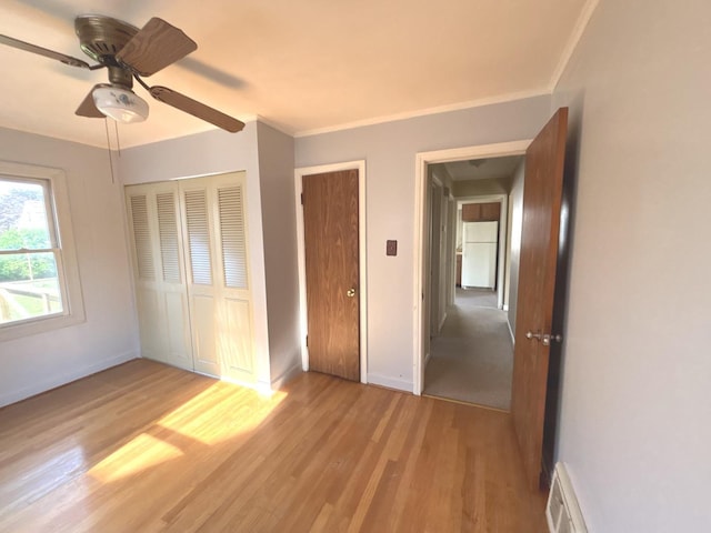 5404 Kimball Pl, Oak Lawn, IL 60453 - unfurnished bedroom featuring freestanding refrigerator, light wood-style flooring, a closet, baseboards, and crown molding