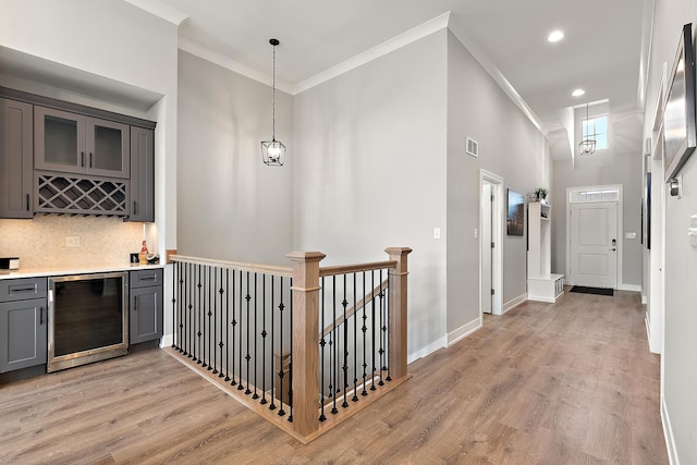 1340 Lacoma Ct, Lockport, IL 60441 - interior space with crown molding, beverage cooler, light wood-type flooring, a towering ceiling, and visible vents