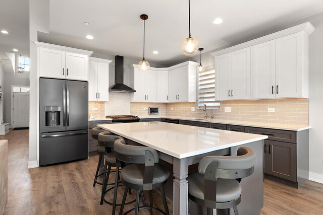 1340 Lacoma Ct, Lockport, IL 60441 - kitchen with wood finished floors, a kitchen island, stainless steel fridge, wall chimney exhaust hood, and a sink