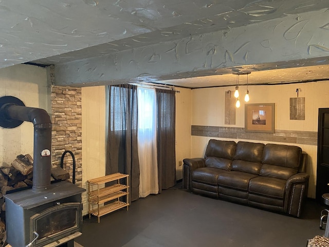 living area with a wood stove and concrete floors