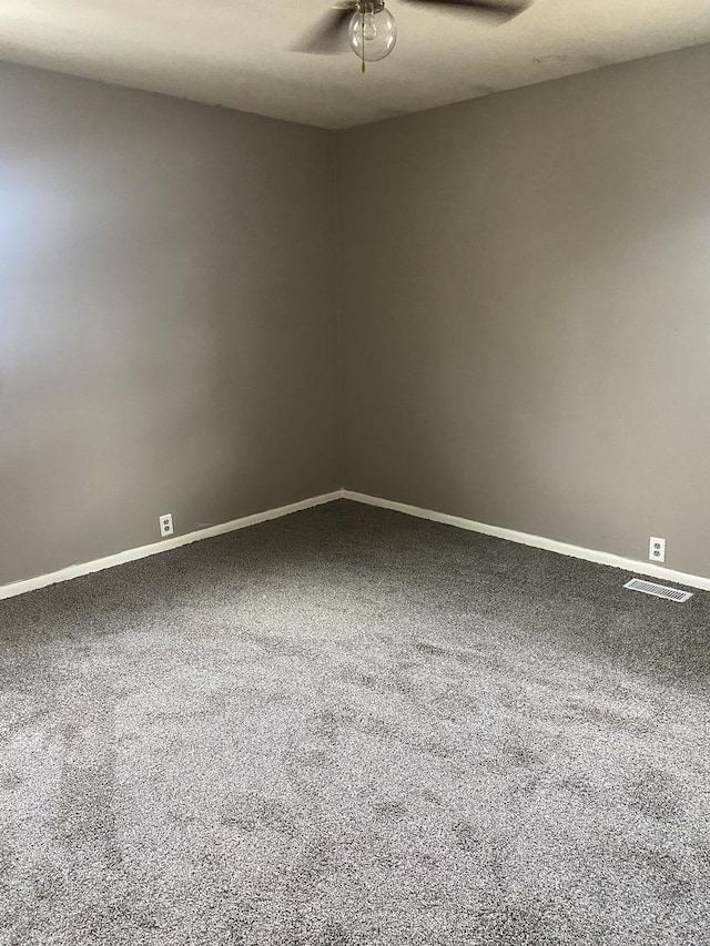spare room with baseboards, visible vents, a ceiling fan, and carpet