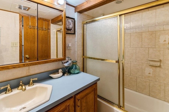 bathroom with bath / shower combo with glass door, visible vents, and vanity