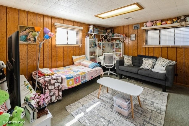 bedroom featuring wood walls and carpet floors
