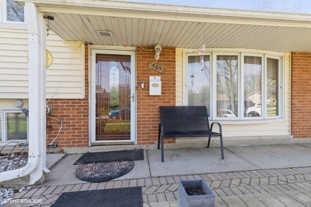 doorway to property featuring brick siding