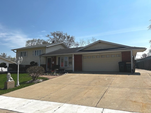 split level home with a front yard, driveway, a garage, and brick siding