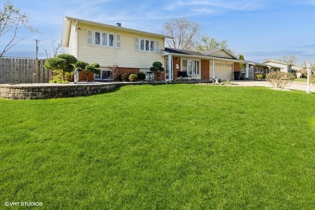 split level home featuring brick siding, fence, a garage, driveway, and a front yard