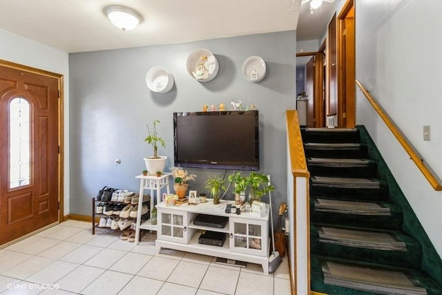 foyer featuring light tile patterned floors, baseboards, and stairs