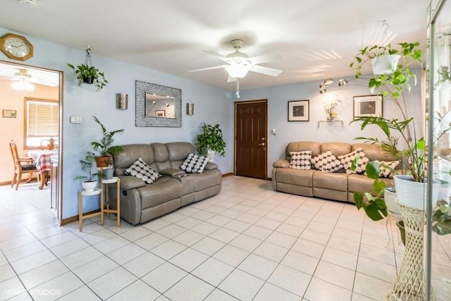 living area with light tile patterned flooring, ceiling fan, and baseboards
