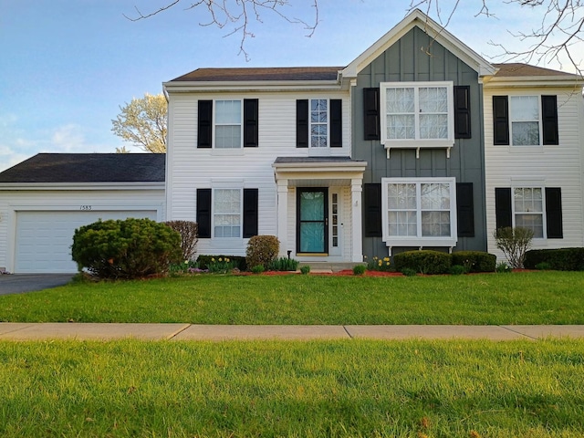 colonial home featuring board and batten siding, a front lawn, and a garage