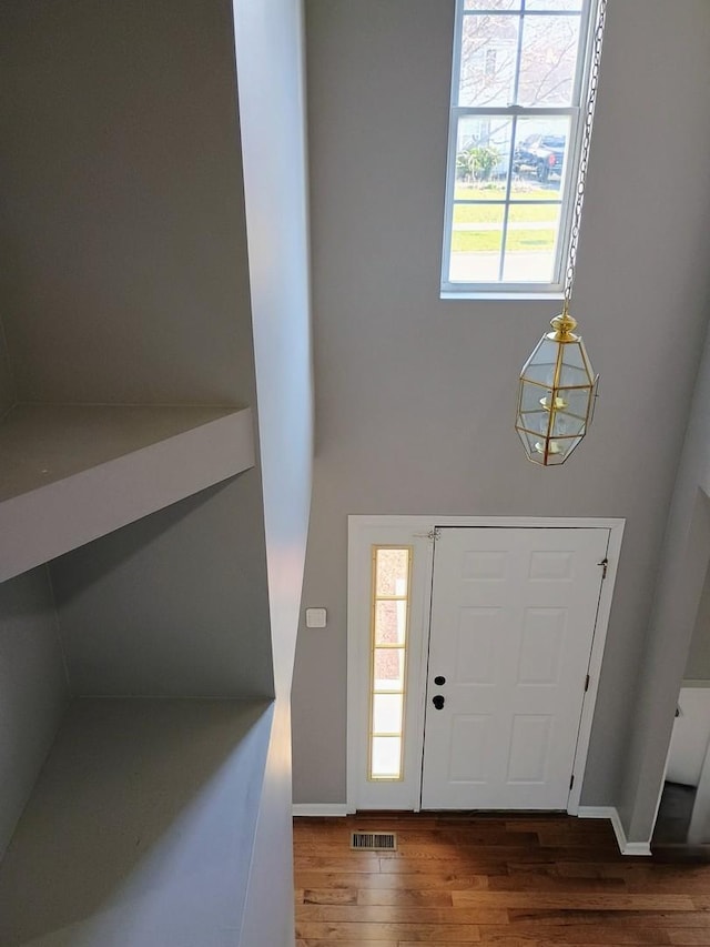 entryway featuring wood finished floors, visible vents, and baseboards