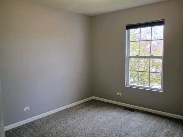 carpeted spare room with visible vents and baseboards