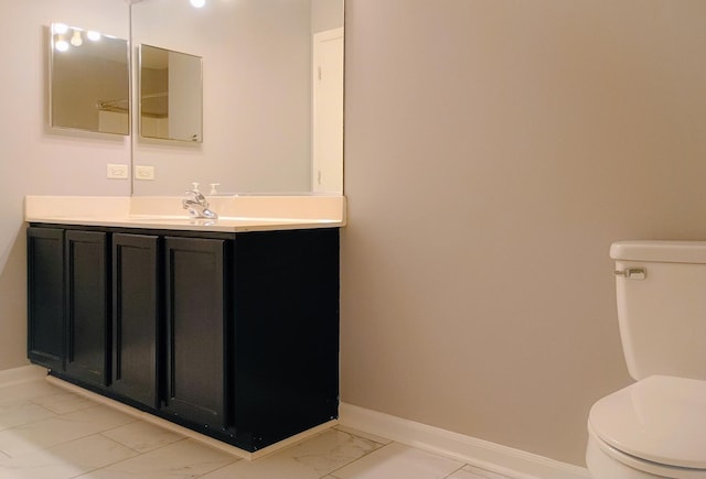 bathroom featuring toilet, marble finish floor, and baseboards