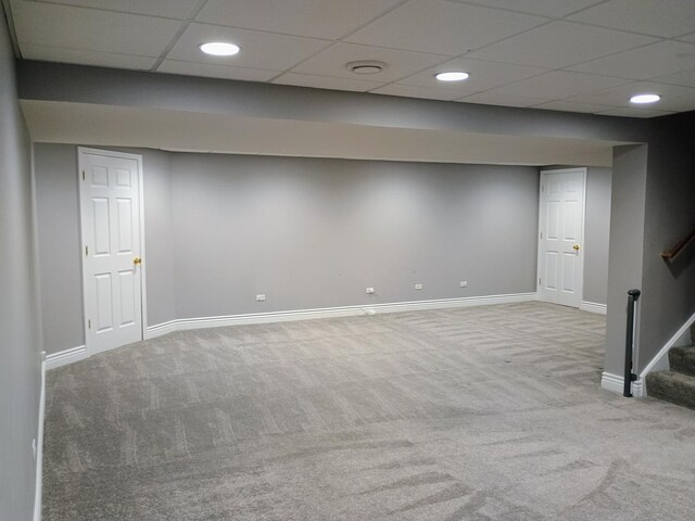 finished basement featuring baseboards, stairway, and carpet