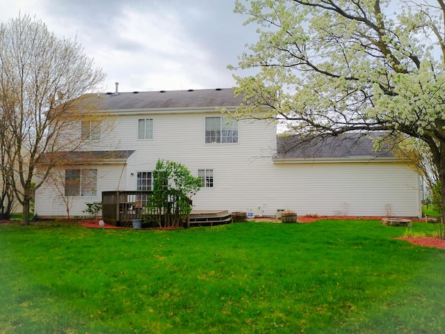back of house featuring a deck and a yard