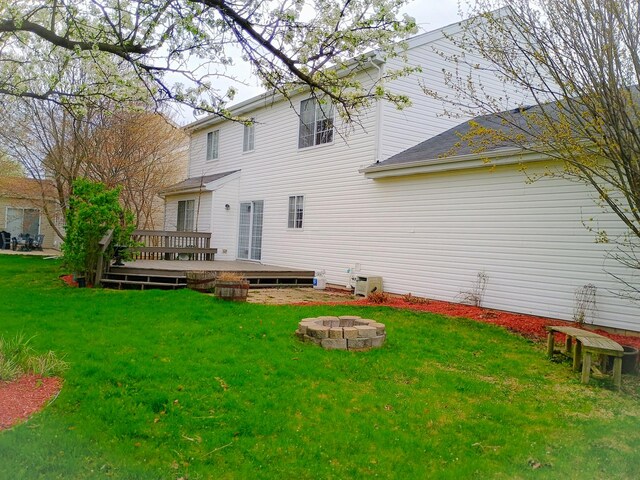 rear view of house featuring an outdoor fire pit, a yard, and a wooden deck