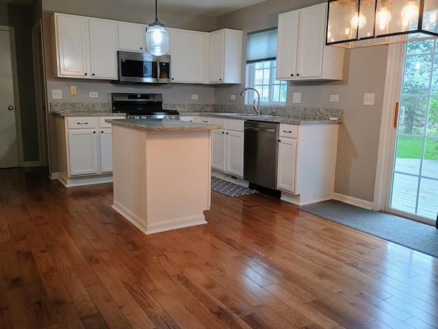 kitchen featuring white cabinetry, appliances with stainless steel finishes, dark wood-type flooring, and a sink