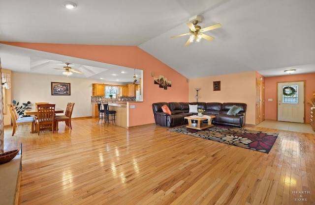 living room featuring light wood-style floors, a wealth of natural light, a ceiling fan, and lofted ceiling