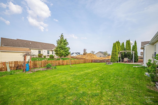 view of yard featuring a fenced backyard, a patio, a fire pit, and a residential view