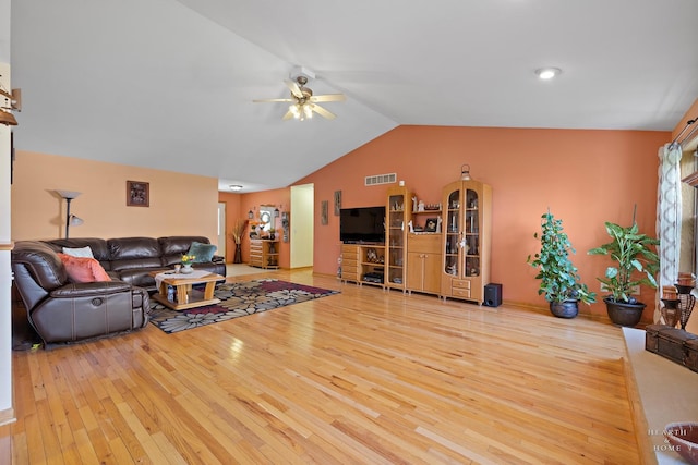 living area featuring a ceiling fan, visible vents, lofted ceiling, and hardwood / wood-style flooring