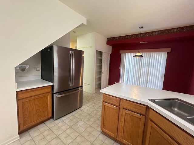 414 E Victoria Cir Unit 414, North Aurora, IL 60542 - kitchen featuring freestanding refrigerator, brown cabinets, pendant lighting, and light countertops