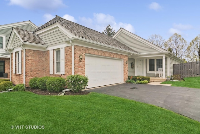 ranch-style house with a front yard, a garage, brick siding, fence, and aphalt driveway