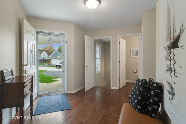 entryway featuring baseboards and dark wood-style floors