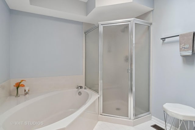 bathroom featuring a bath and a stall shower