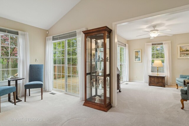 doorway to outside with visible vents, carpet, a ceiling fan, baseboards, and vaulted ceiling