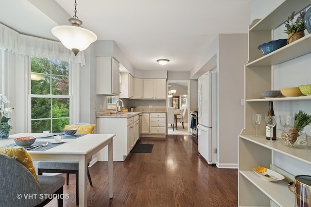 kitchen featuring white cabinets, open shelves, dark wood-style floors, freestanding refrigerator, and pendant lighting