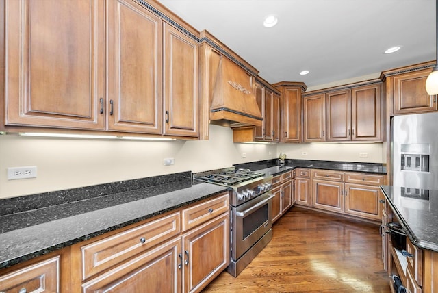 kitchen with dark stone counters, recessed lighting, stainless steel appliances, and dark wood-type flooring