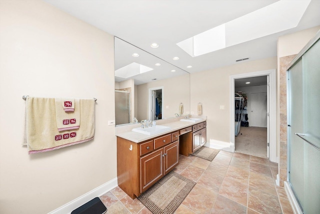 full bath featuring a sink, a stall shower, double vanity, a walk in closet, and a skylight