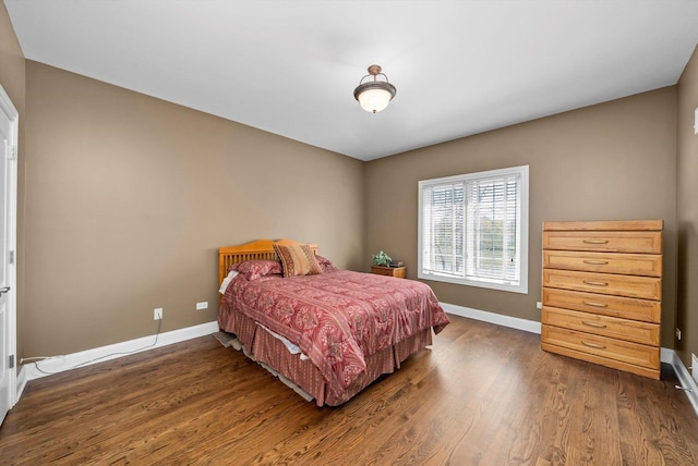 bedroom with dark wood-type flooring and baseboards