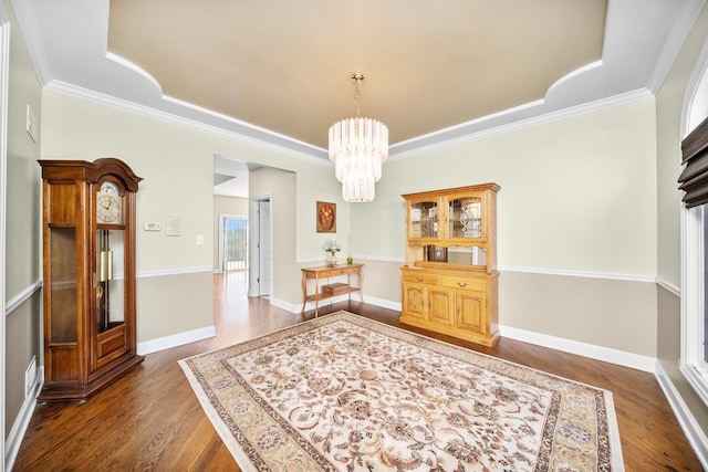 dining room with an inviting chandelier, ornamental molding, and dark wood finished floors