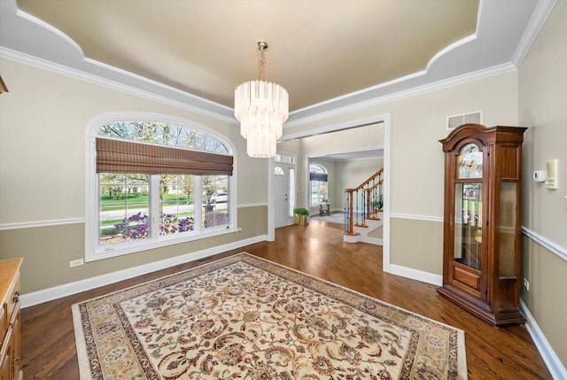 entryway with a chandelier, a healthy amount of sunlight, and dark wood-style floors